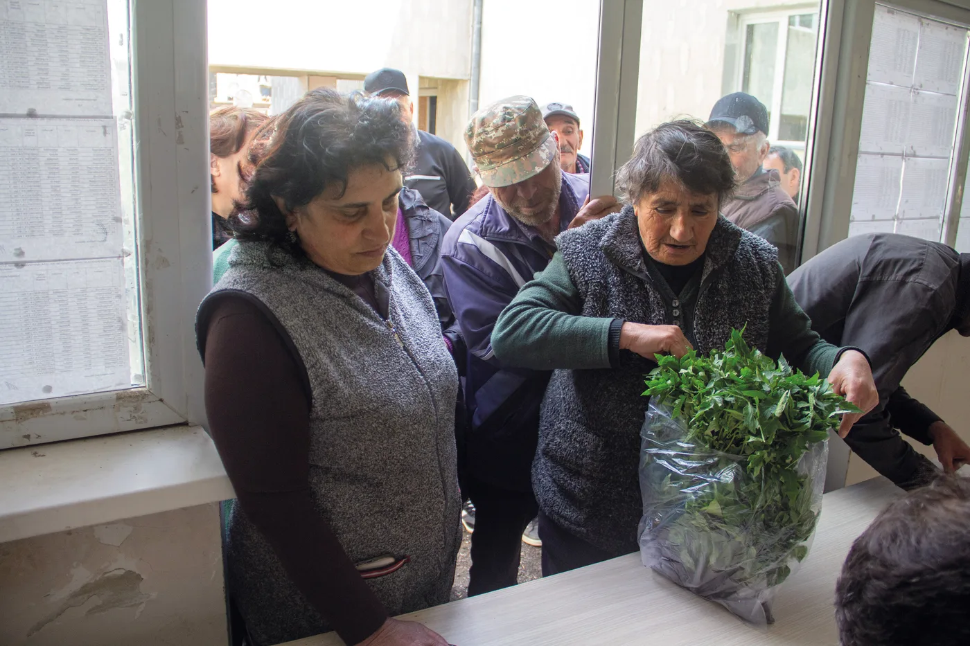 Des villageoises reçoivent des bottes de semis de légumes lors de la distribution dans le bâtiment communal d’Angeghakot
