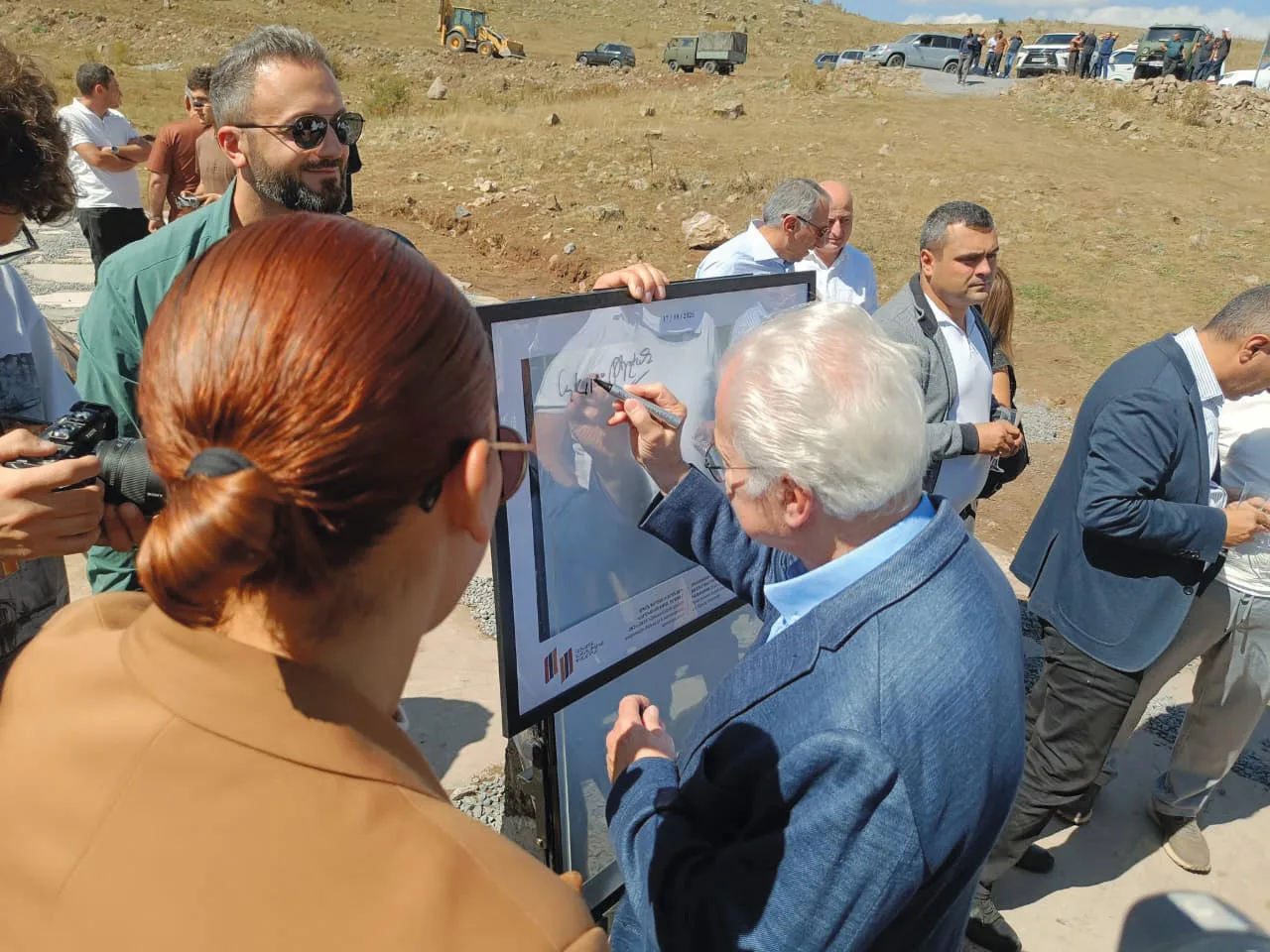 Représentants des donateurs signant une plaque encadrée lors d’une cérémonie sur le chantier du canal