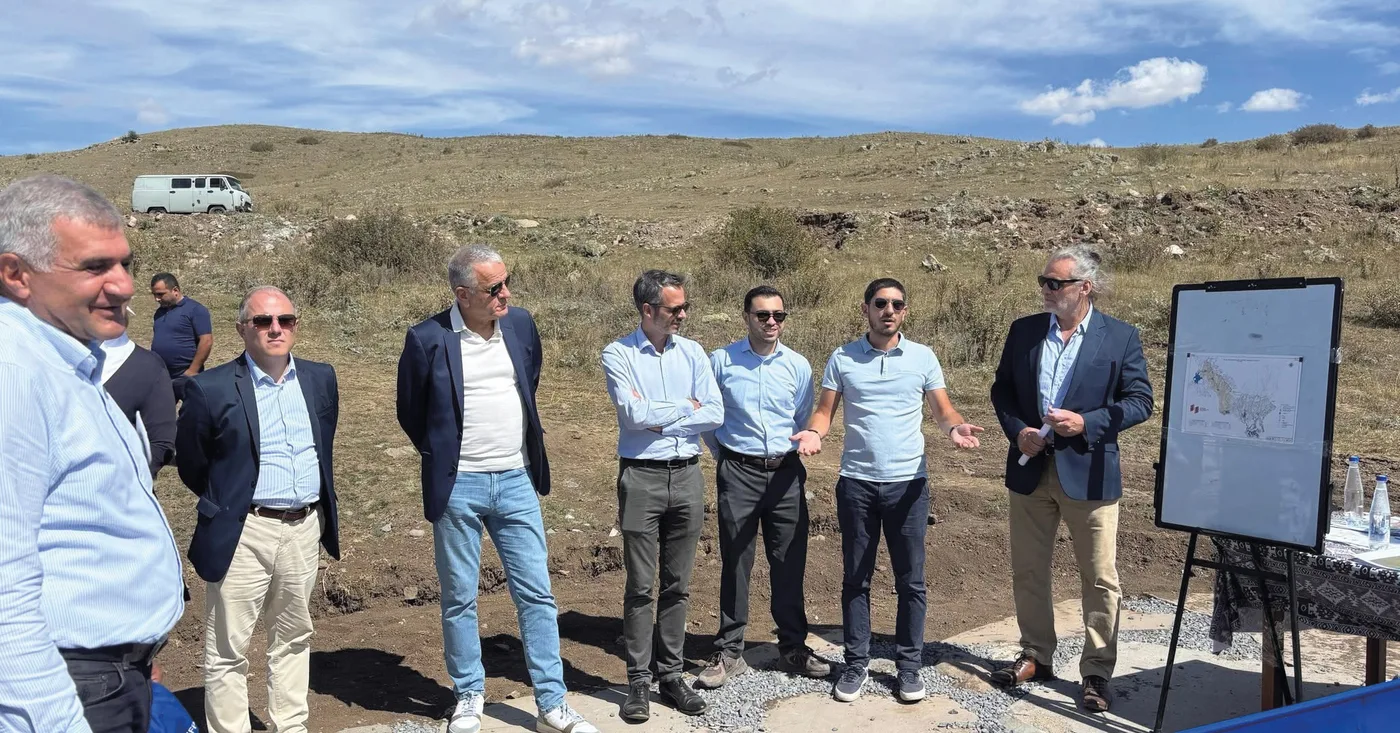Ambassadeurs européens en costume sur le chantier du canal, devant un plan du projet posé sur un chevalet